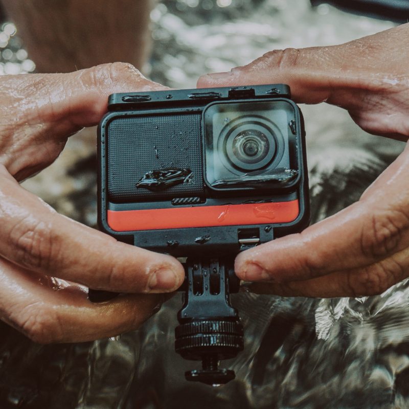 A closeup of a man holding a GoPro camera